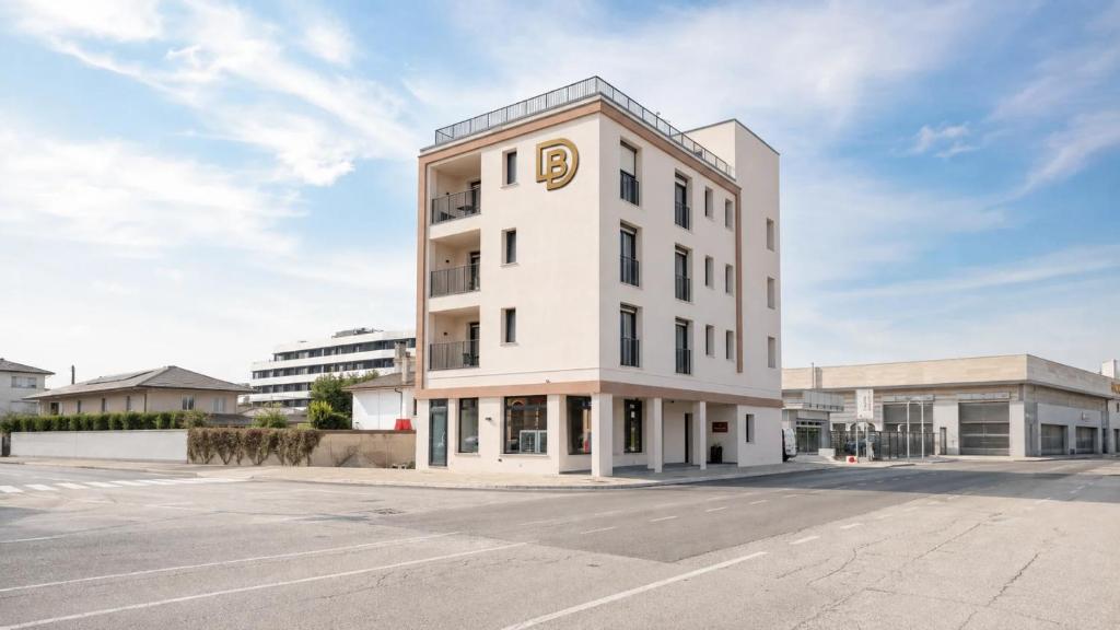 a white building with a gold sign on it at DB Residence Luxury Stay in Noventa di Piave