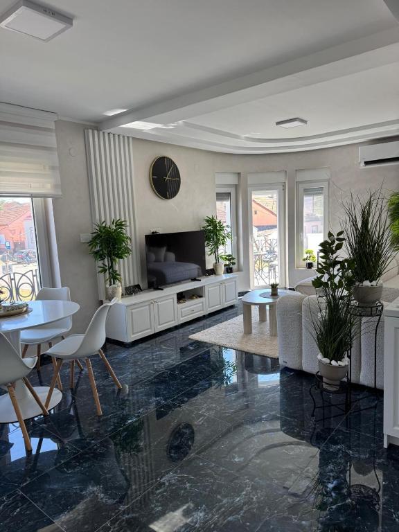 a living room with a couch and a table and chairs at Angel Luxury Apartment in Kikinda