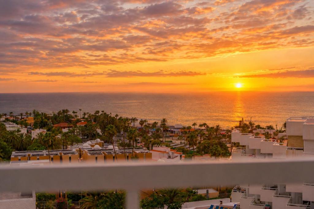 a view of the sunset from the balcony of a resort at Bella vista in Playa Fañabe