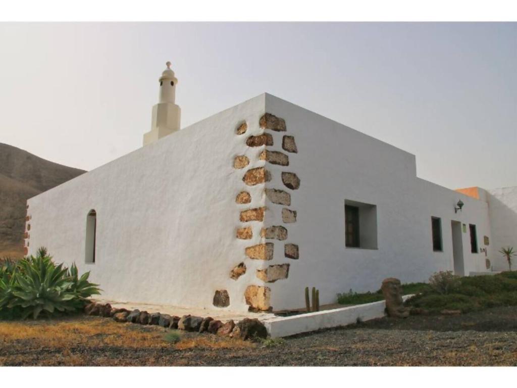 a white church with a chimney on the side of it at Casa Rural los Ajaches in Yaiza