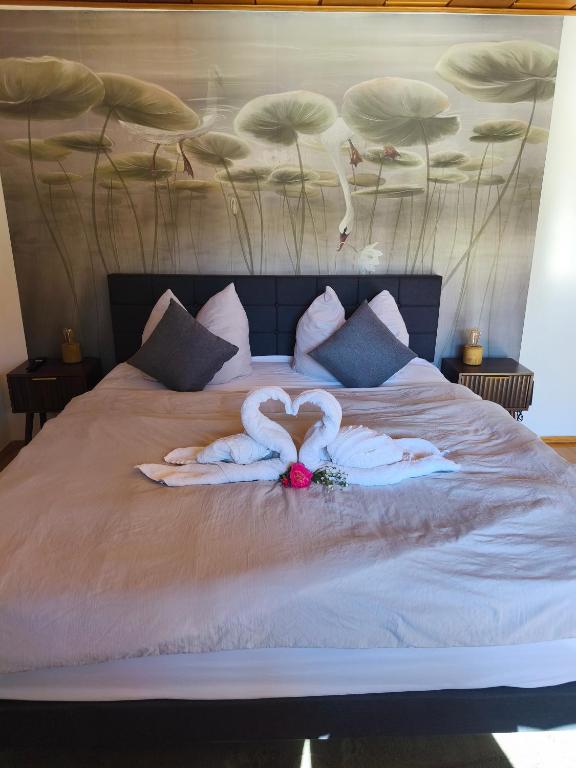 two swans making a heart on a bed at Ferienwohnung Burgjuwel Burghausen nahe weltlängster Burg zentral 24h Check in in Burghausen