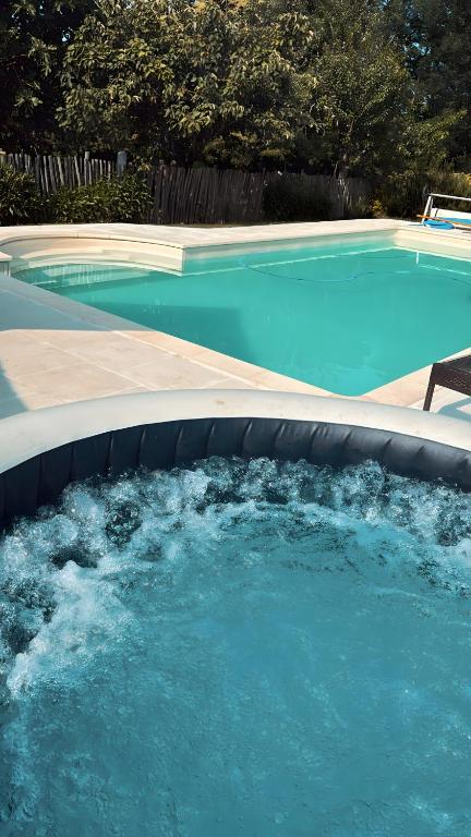 a swimming pool with blue water in a backyard at Chez Fayolle in Montagnac-la-Crempse