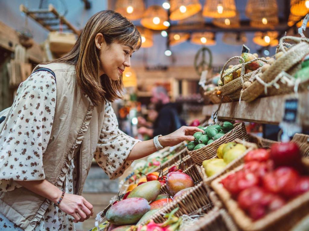 a woman shopping in a grocery store with fruits and vegetables at Mercure Tianshui Downtown in Tianshui