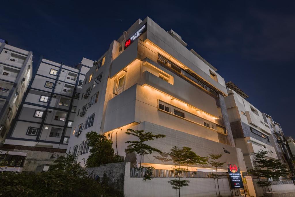 a tall white building with lights on it at Wild Wings Hotel Narsingi in Hyderabad