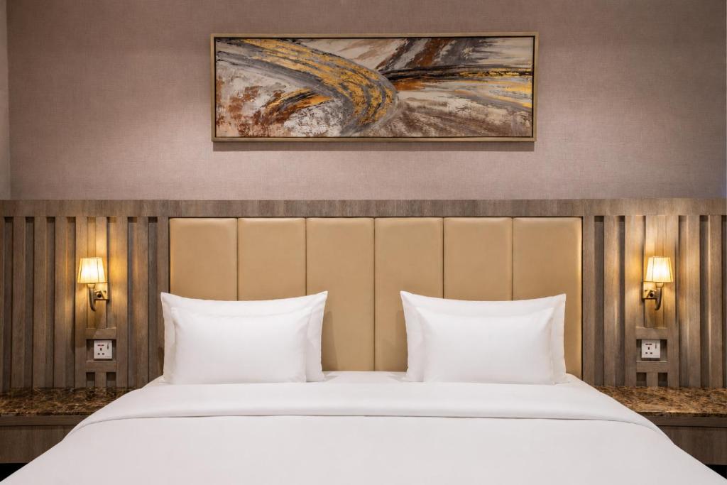 a bedroom with a large bed with two pillows at NARS Plus Serviced Apartments - Al Nuzha in Jeddah