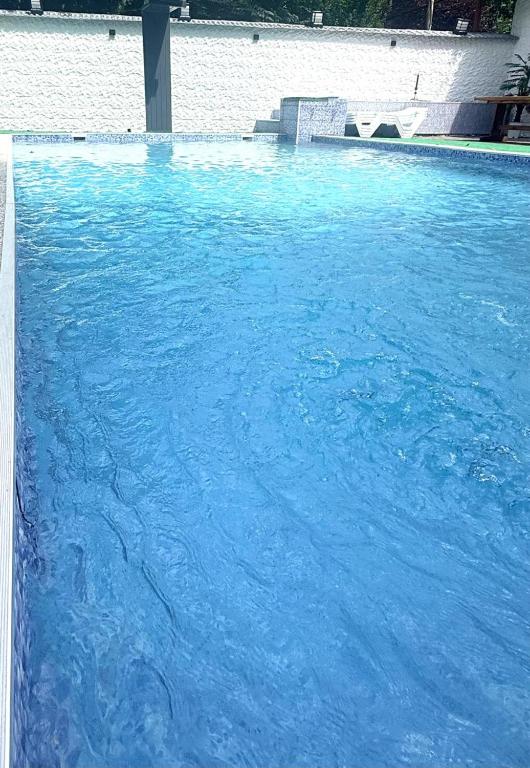 a large swimming pool with blue water in it at Golden Sunset Batumi Private Pool Villa in Batumi