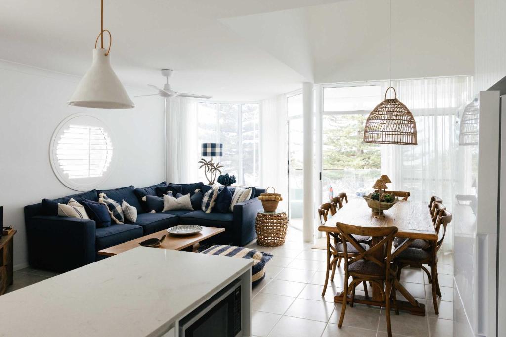 a living room with a blue couch and a table at La Ronde Three - Unit 3 - Oceanstays in Yamba