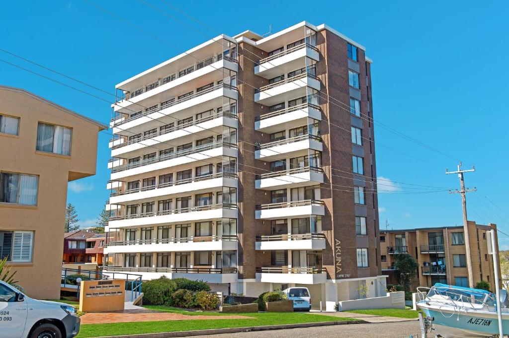 a tall apartment building in a parking lot at Akuna 14, 6 Joffre Street in Port Macquarie