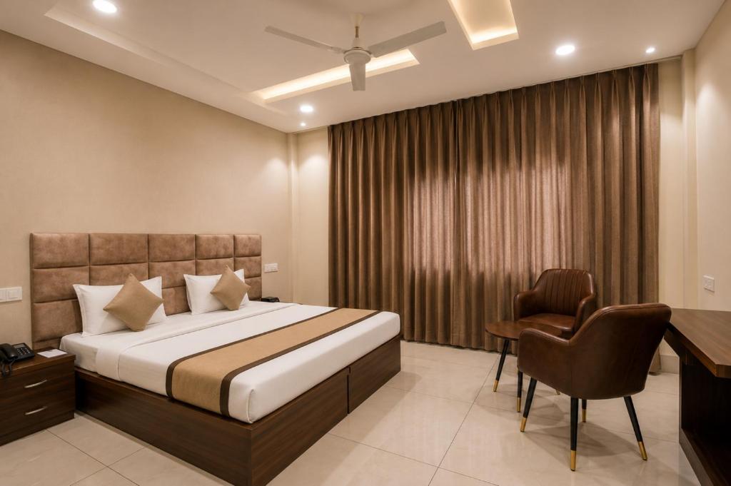 a bedroom with a bed and a desk and a chair at Hotel Elite La Prizm Near Zirakpur Bus Stand in Zirakpur