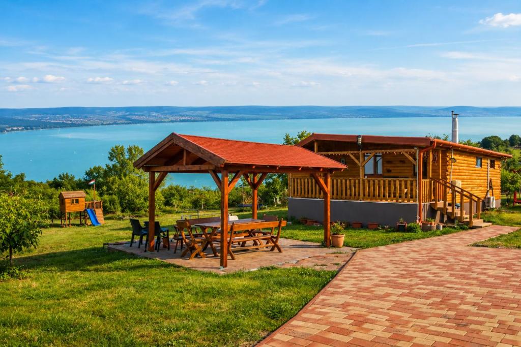 a cabin with a picnic table and a gazebo at Ádám nyaralóház in Balatonalmádi