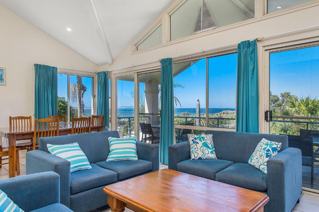 a living room with two blue couches and a table at Breakers 2 in Crescent Head