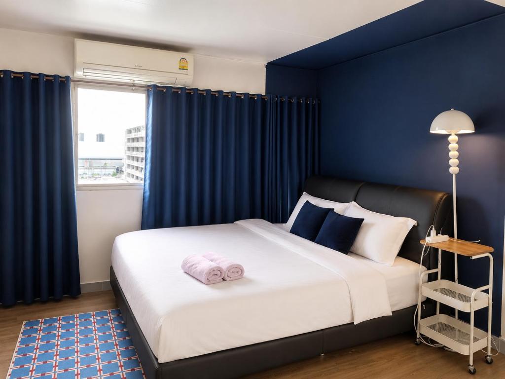 a bedroom with a large bed with blue walls at IMPACT popular condo c5 แม่ตังค์ in Ban Bang Phang