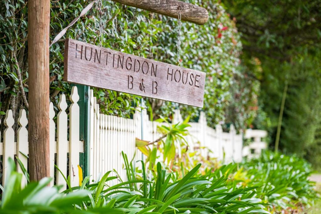 a sign that readsfunction house bd in front of a fence at Historic Huntingdon House in Wauchope