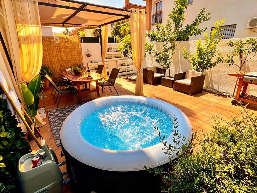a jacuzzi tub on a patio with a table at Casa rural Lomalinda in Granada