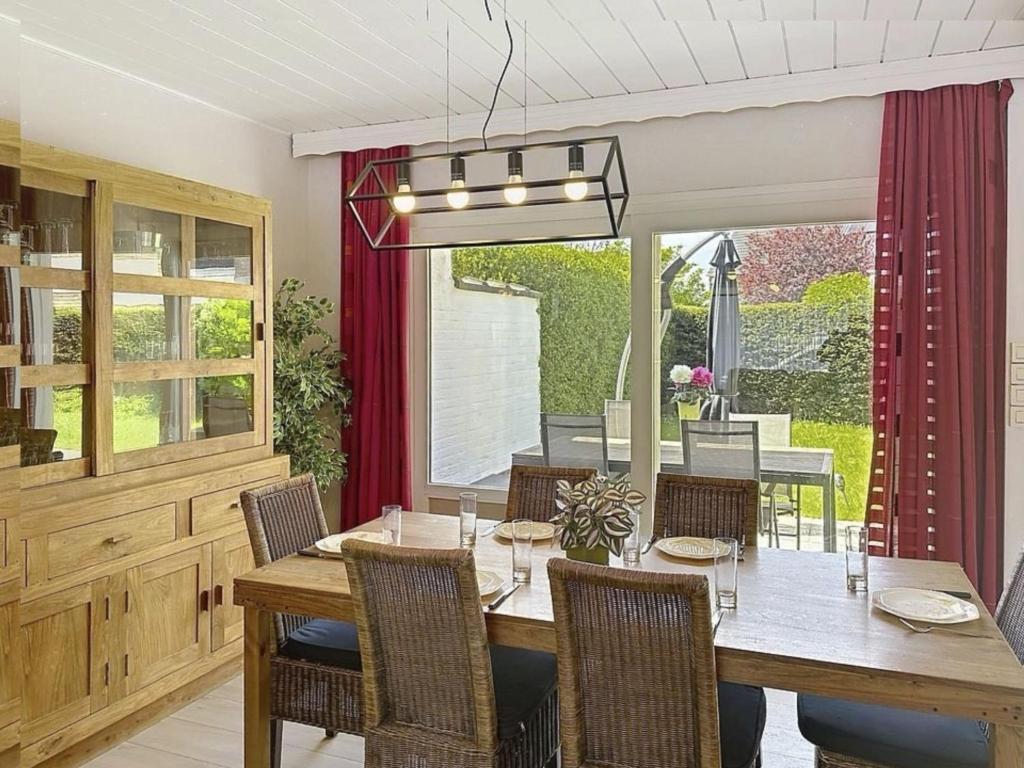 a dining room with a wooden table and chairs at Holiday Home Ruiterlaan with parking by Interhome in Bredene