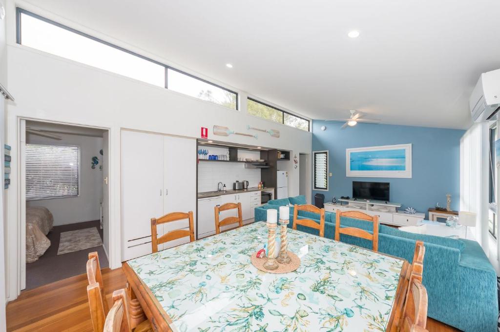 a dining room and kitchen with a table and chairs at Sandy Shores, Serenity Resort in Diamond Beach