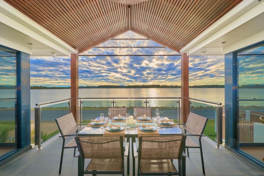 a dining table on a balcony with a view of the water at Riverside Luxury in Port Macquarie