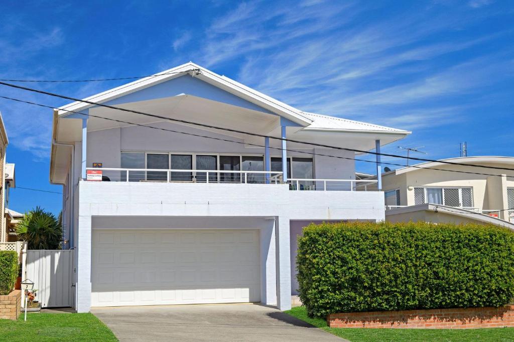 a white house with a garage in front of it at Vaka Malua, 7 Scott Street in Crescent Head