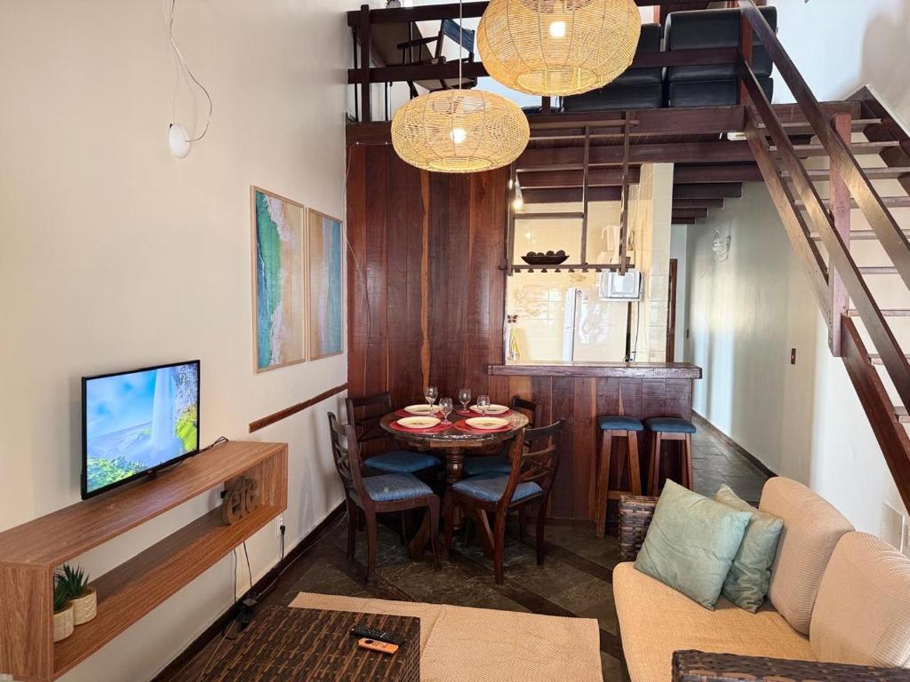 a living room with a dining room table and a staircase at Duplex 450m da Praia do Peró, Roupa Cama e Banho, Wi-Fi, TV a Cabo, Estacionamento in Cabo Frio