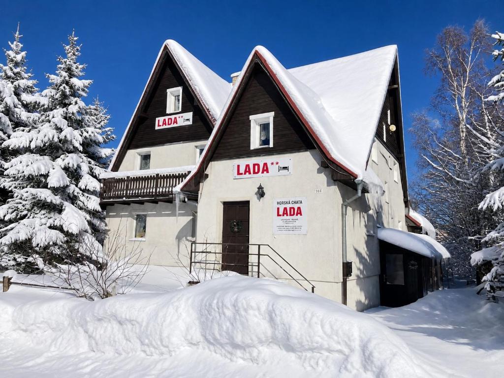 a large building in the snow with snow covered trees at Horská chata LADA in Loučná pod Klínovcem