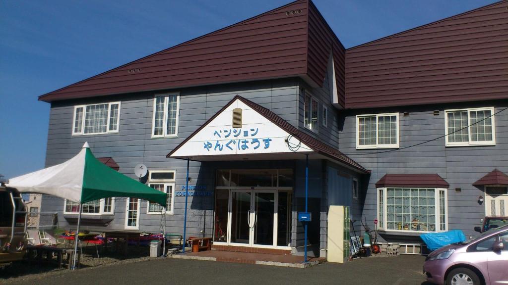 ein Gebäude mit einem Schild auf der Vorderseite in der Unterkunft Pension Young House in Furano