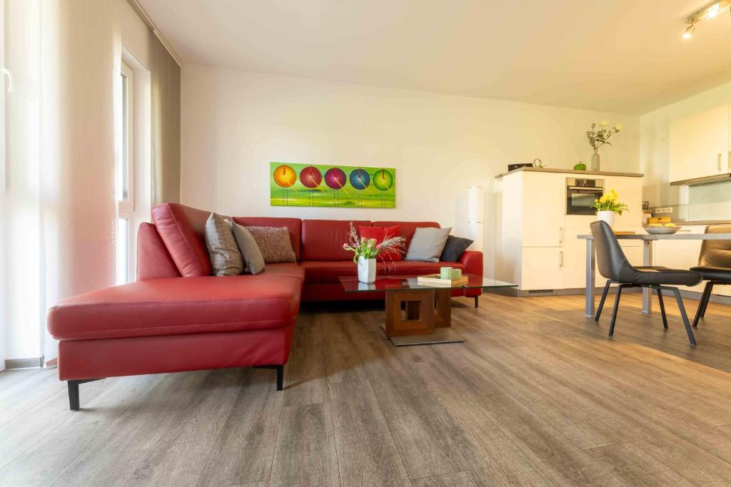 a living room with a red couch and a table at Ferienwohnung Kurpark in Xanten