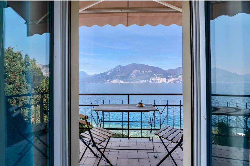 a view from the balcony of a house with a table and chairs at Apartment Di Lago by GardaDoma in Brenzone sul Garda