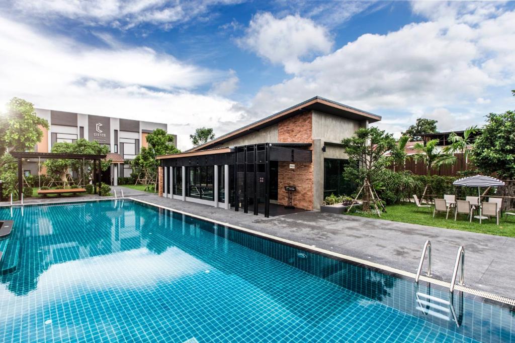 an image of a swimming pool in front of a house at Cresco Hotel Buriram in Buriram