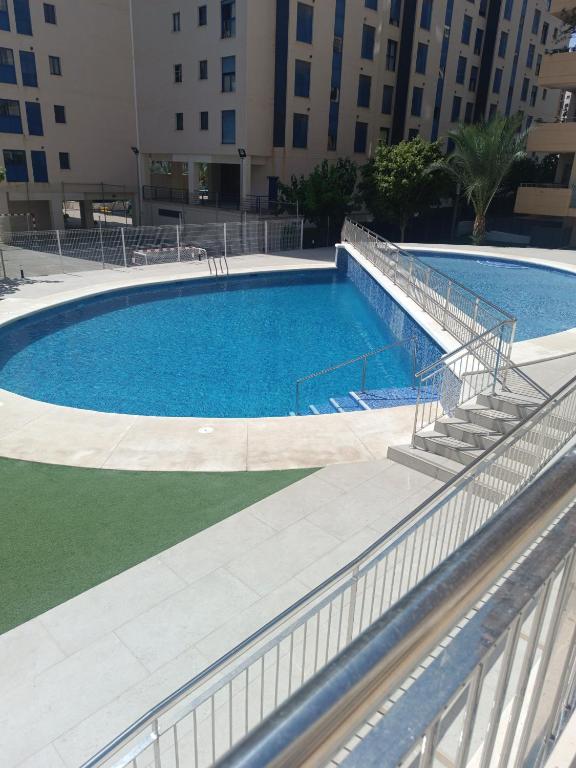 a large swimming pool with stairs next to a building at Fantástico apartamento playa in Cala de Finestrat