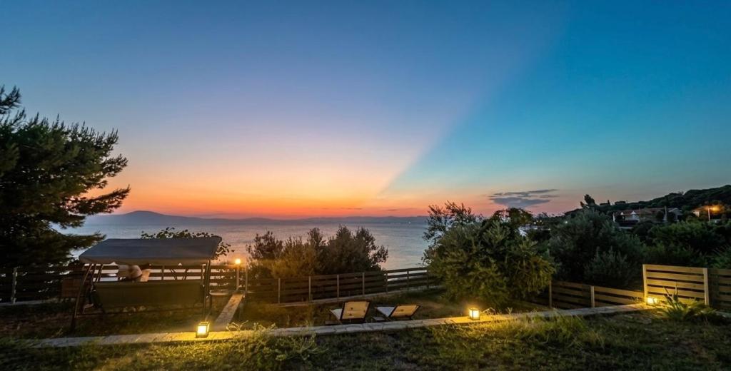 a view of a sunset from a hill with lights at Sadova Messinia Pearl Cozy Seafront House in Avía