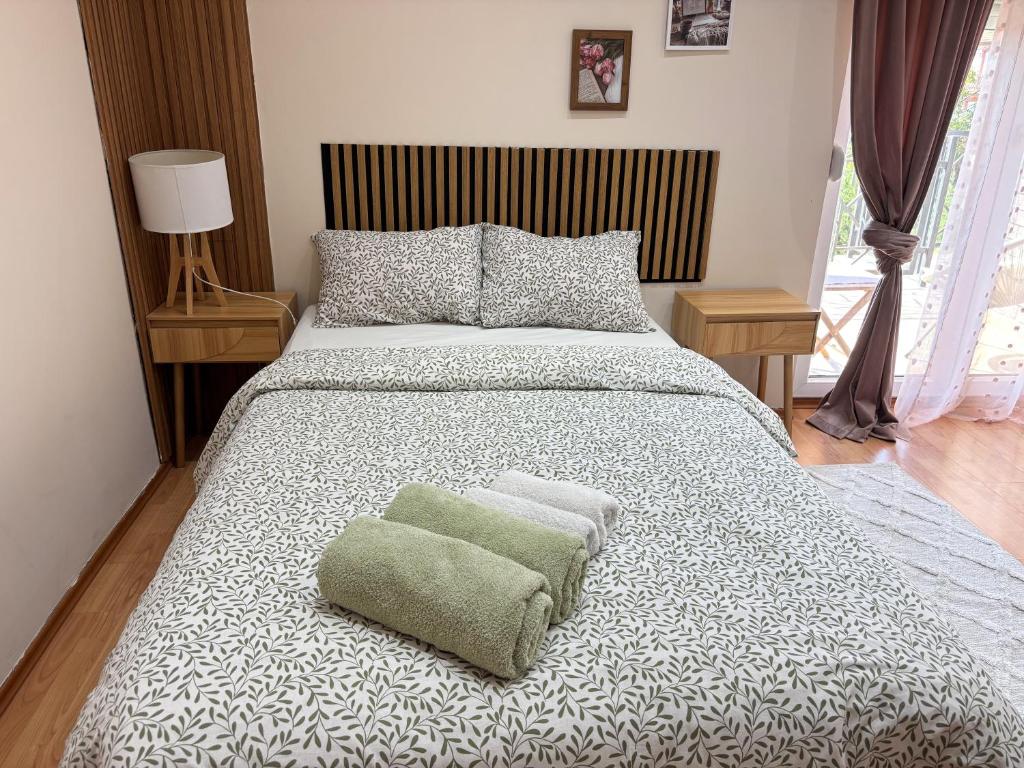 a bedroom with a large bed with a green ottoman at Cozy Family House in Lazarevac
