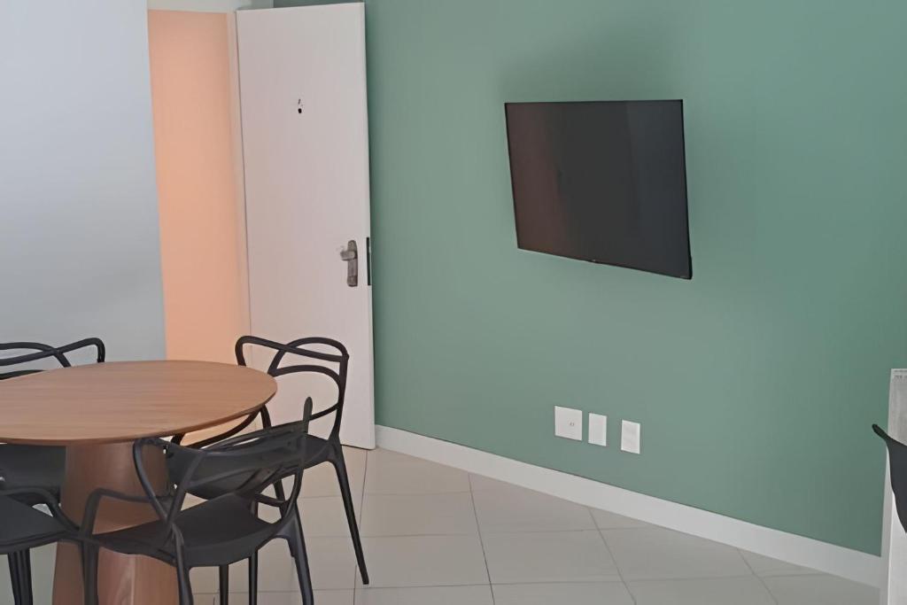 a dining room with a table and chairs and a television at Hotel Residence in Rio de Janeiro