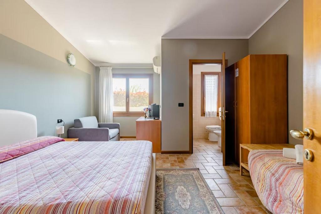 a bedroom with a bed and a living room at Agriturismo Taglio del Re in Jesolo