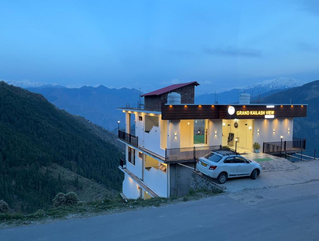 a house with a car parked in front of it at Grand Kailash view homestay -near Khajjiar in Dalhousie