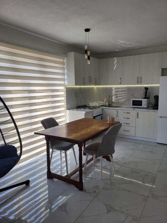 a kitchen with a wooden table and chairs at Jordanovi Premium Apartment in Kavadarci
