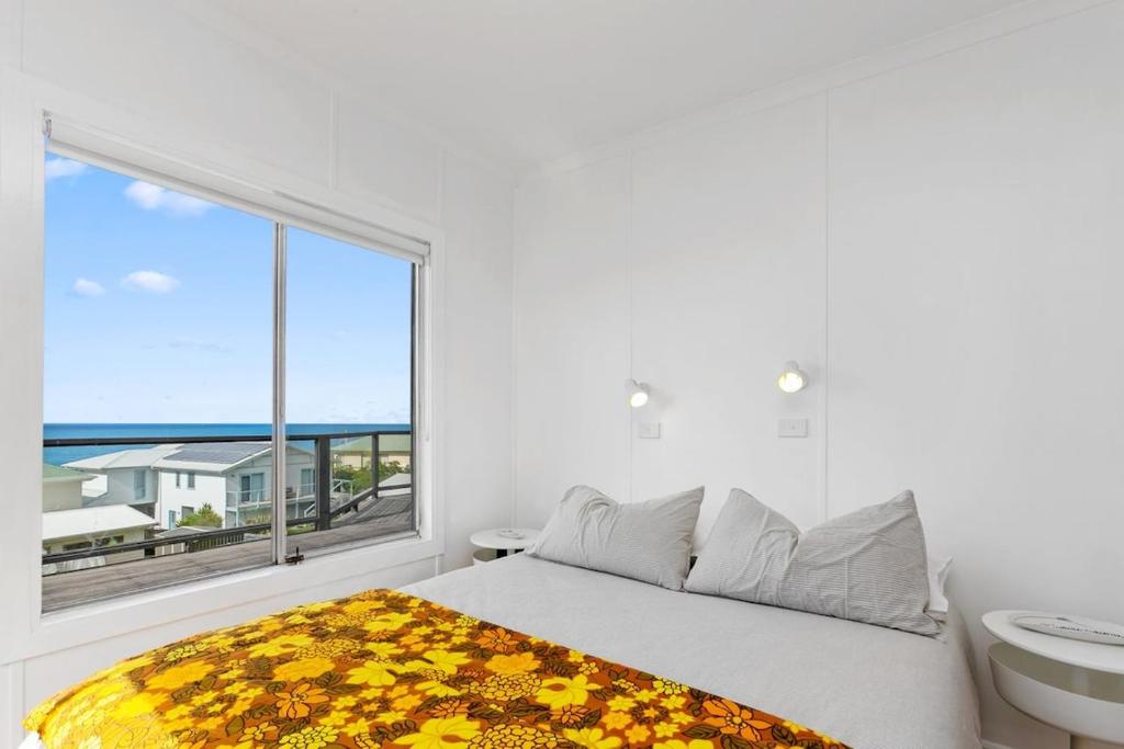 a bedroom with a bed and a large window at Blue Surf - BYO Linen in Apollo Bay
