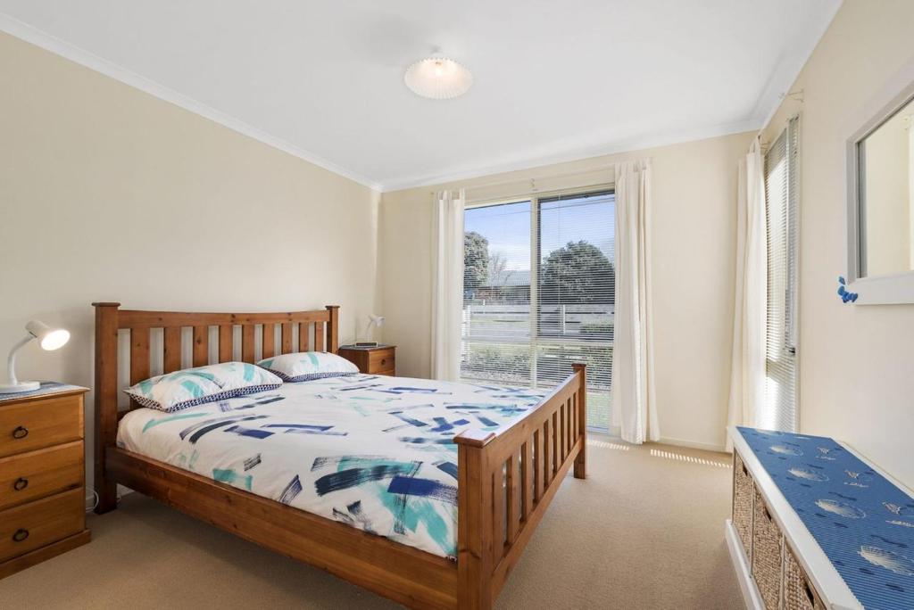 a bedroom with a bed and a large window at Budget By The Bay in Apollo Bay