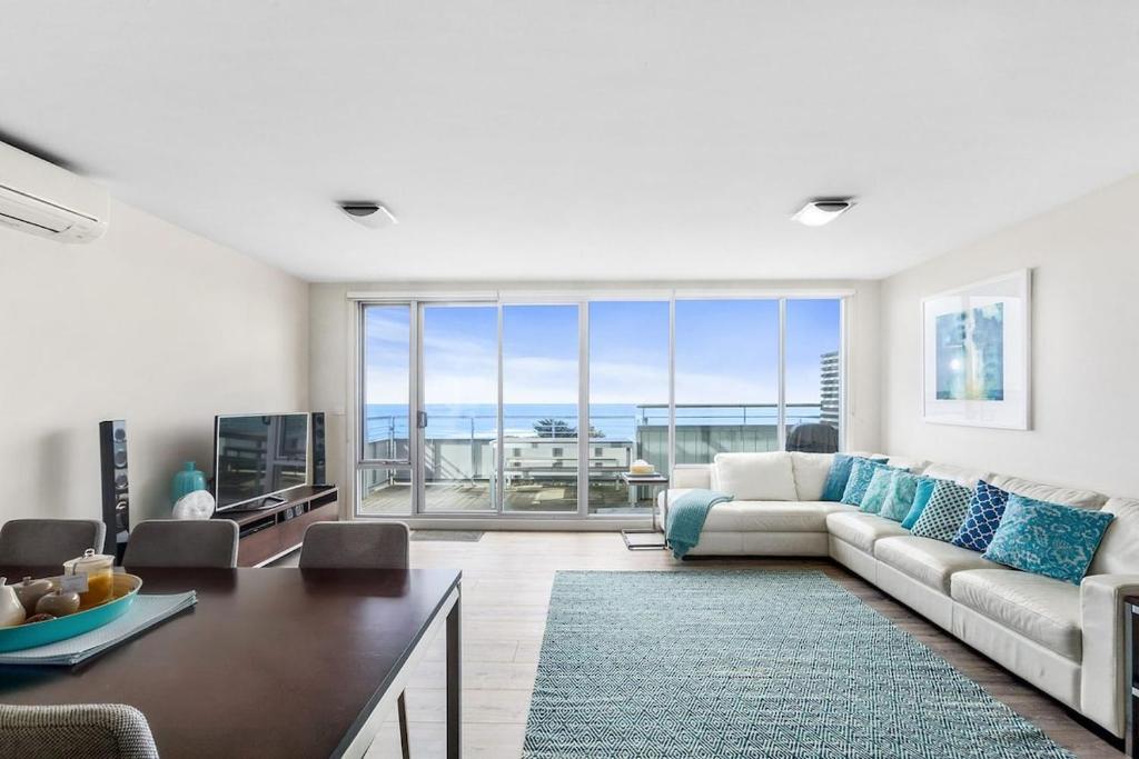a living room with a couch and a large window at Point Grey Apartment 13 in Lorne