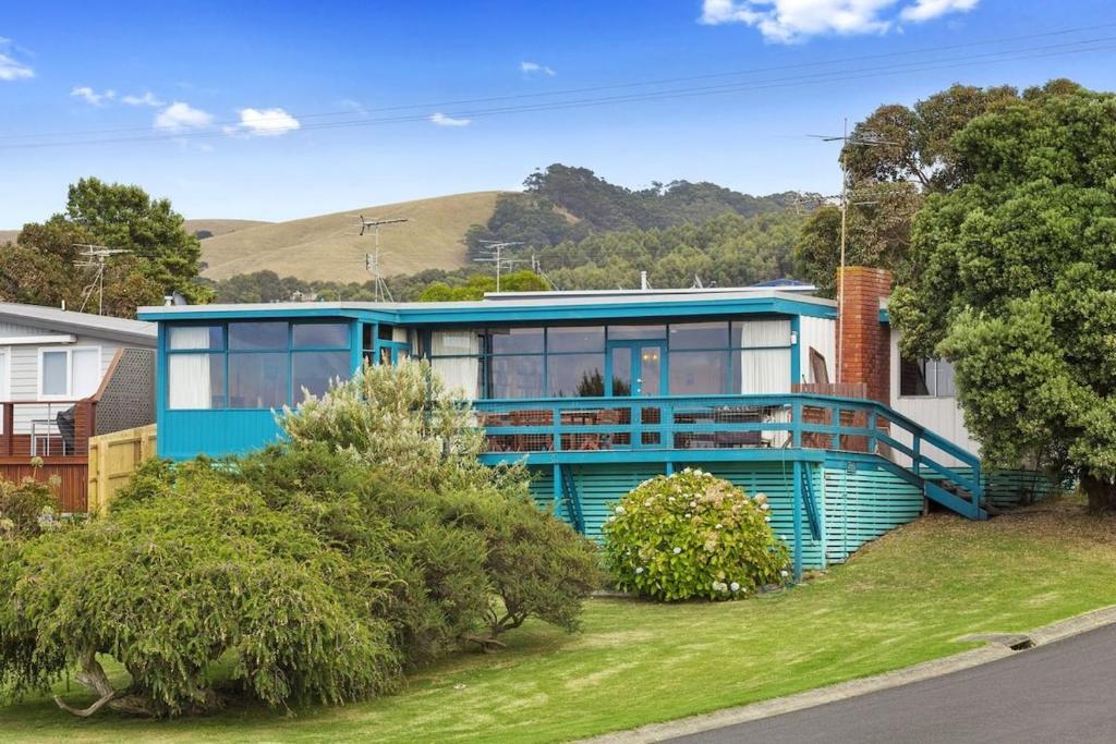 a blue and white house with trees in front of it at Aqua Blue in Apollo Bay