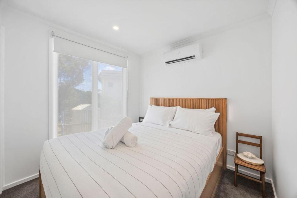 a bedroom with a bed with a stuffed animal on it at AquaLuna Beach House in Aireys Inlet