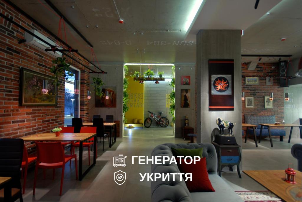 a restaurant with tables and chairs and a brick wall at Cubby Hotel in Lviv