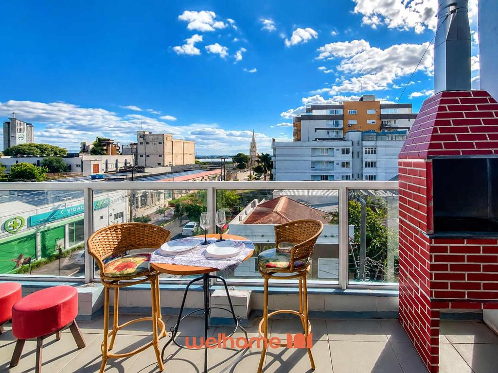 a patio with a table and chairs on a balcony at Cobertura com Vista e Conforto no RS in Santo Ângelo