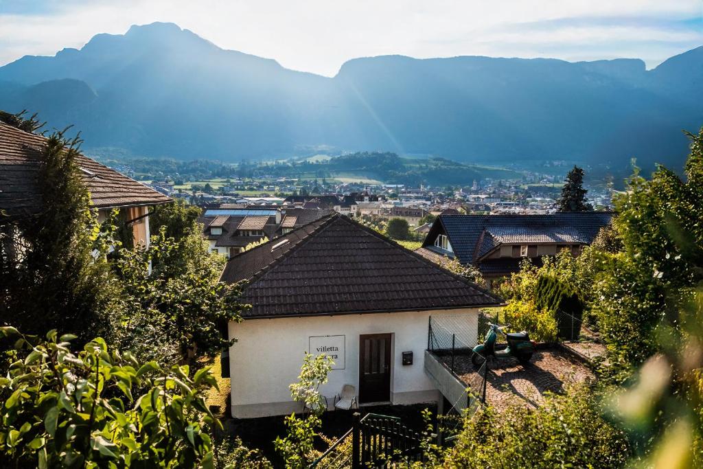 a small white house with mountains in the background at Villetta Allegra in Appiano sulla Strada del Vino