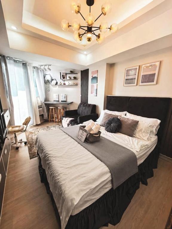 a bedroom with a large bed and a chandelier at Z Crib - Azure North in San Fernando