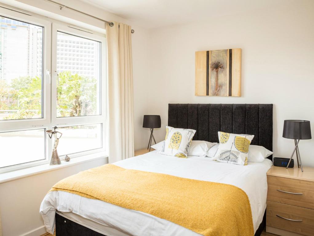 a bedroom with a large bed and two windows at Oakdale at Centrium in Woking