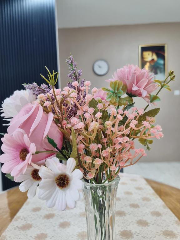 a vase filled with pink and white flowers on a table at HomeStay with Serene Surrounding in Nibung Tebal