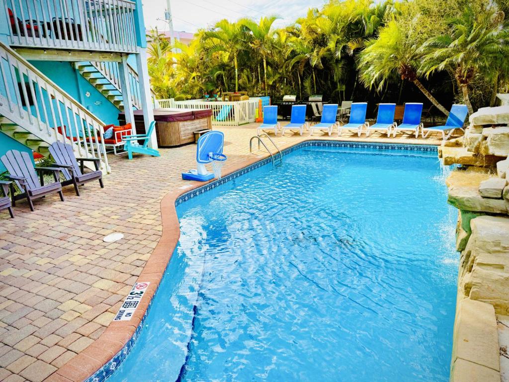 a large swimming pool with blue chairs and a resort at Family Tides in Holmes Beach