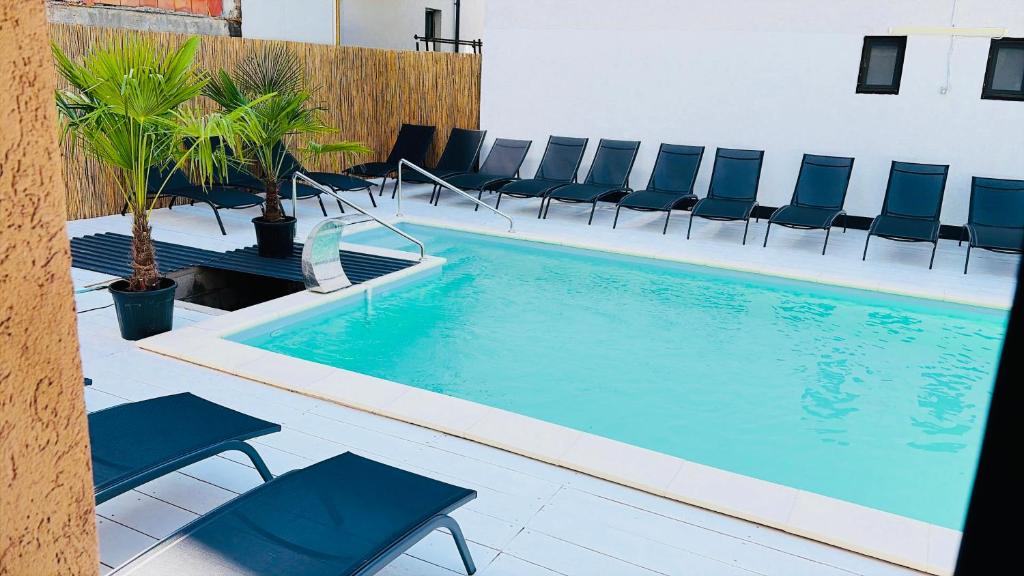 a swimming pool with blue chairs at Pensiunea LOFT Căciulata in Caciulata