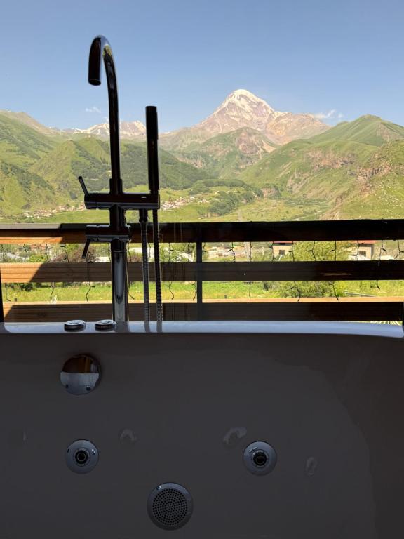 a window with a view of a mountain range at RestArt Cottages in Kazbegi in Kazbegi