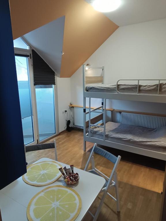 a room with two bunk beds and a table and chairs at Studio Celjeapp in Celje